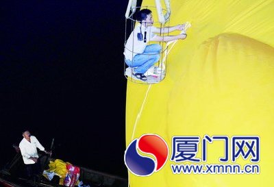 工人給大黃鴨系上繩子，準備起吊