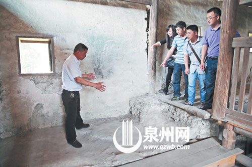 許進丁向游客們比劃著土樓墻體的厚度，當年建造土樓